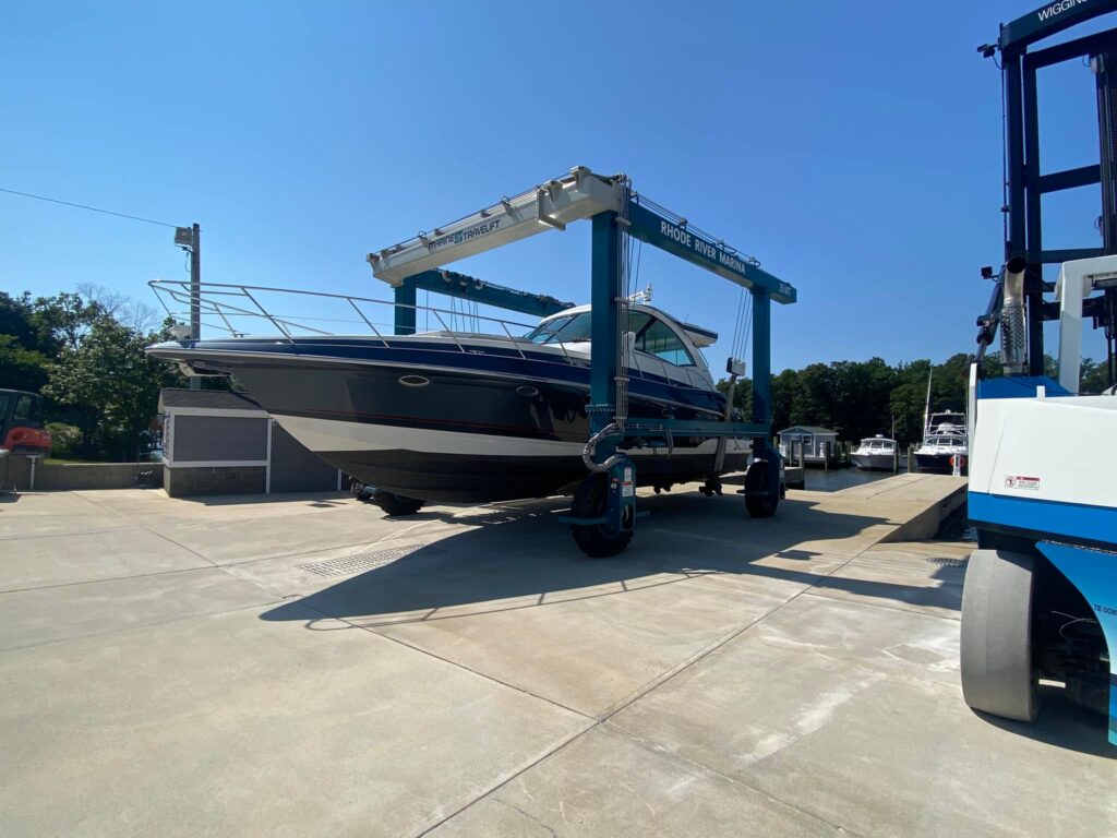 Powerboat being hauled by a travel lift at the marina in preparation for winterization and seasonal storage