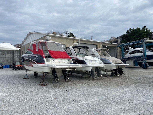 Several powerboats stored on stands at a marina for maintenance, service, and winter storage