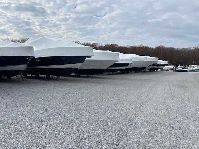 Row of boats shrink-wrapped and stored on land at a marina for winter protection